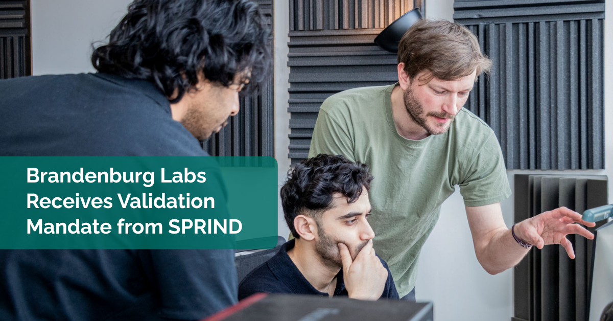 Three engineers discussing technical topics in an auditory lab