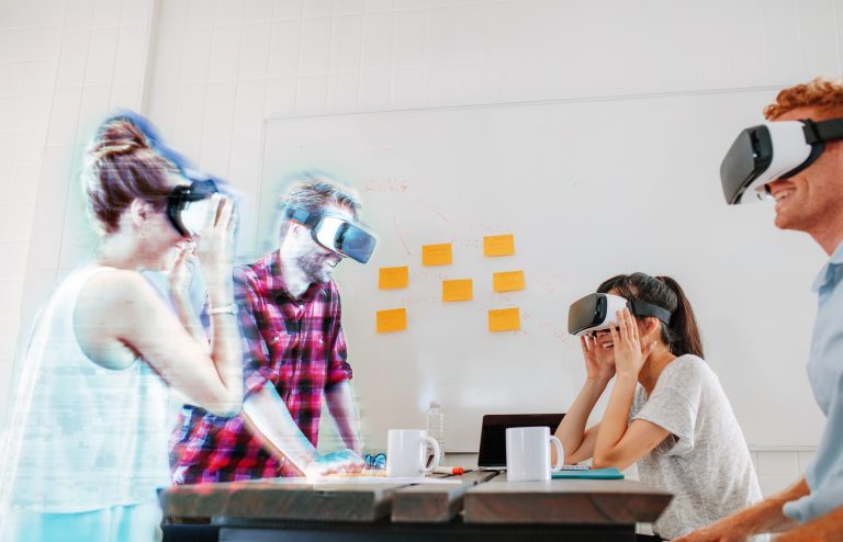 Team of developers working with virtual reality glasses during a business meeting. Young business colleagues brainstorming using VR goggles.